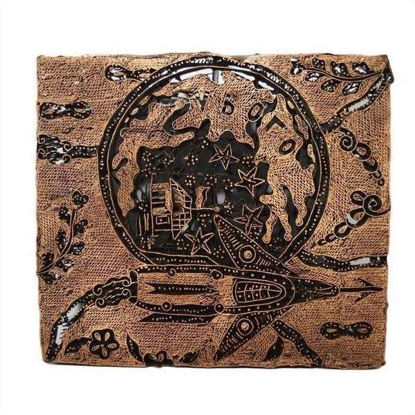 Close-up of a square copper ink block with vintage batik design, featuring a rocket, stars, and abstract patterns.