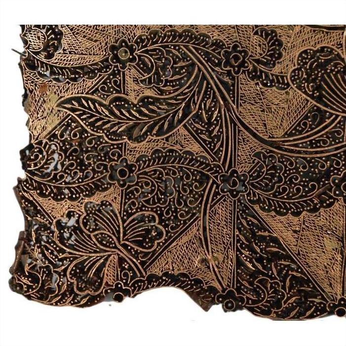Close-up of vintage copper Batek ink block with floral and leaf patterns in brown and black tones.