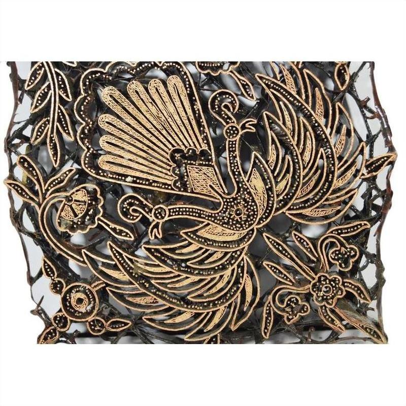 Close-up of vintage copper Batek ink block with intricate floral and bird design for textile printing.