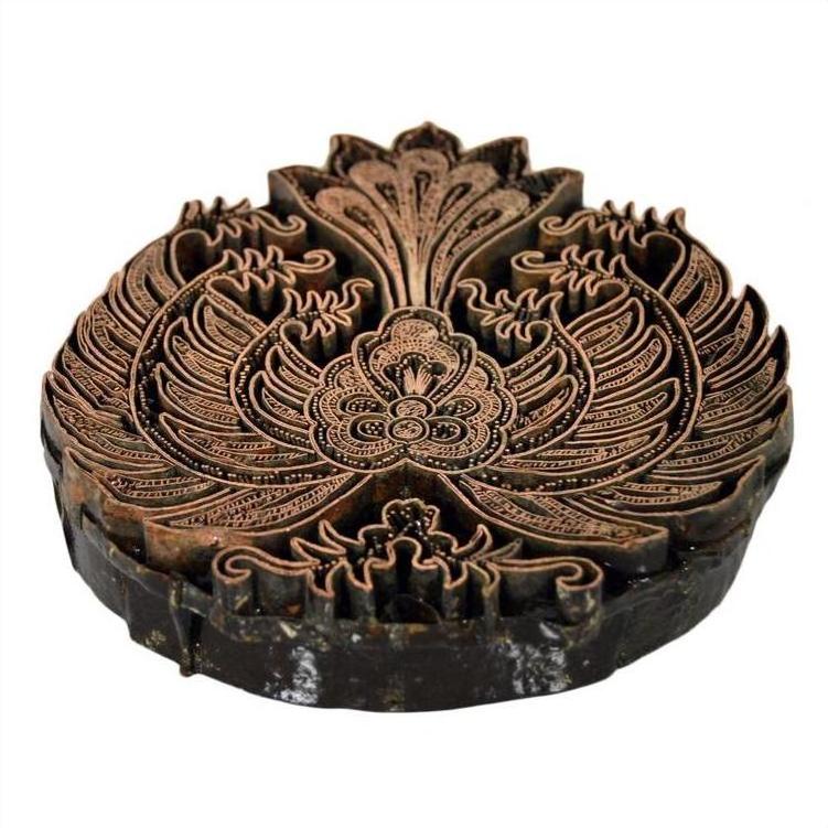 Close-up of vintage copper Batek ink block with detailed floral and leaf designs, used for fabric stamping.