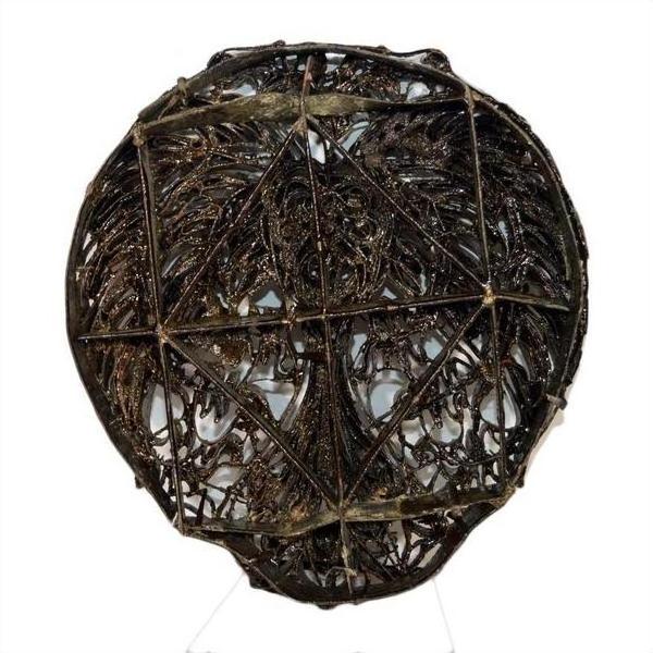 Close-up of vintage copper Batek ink block with geometric wireframe and ornate swirling patterns.