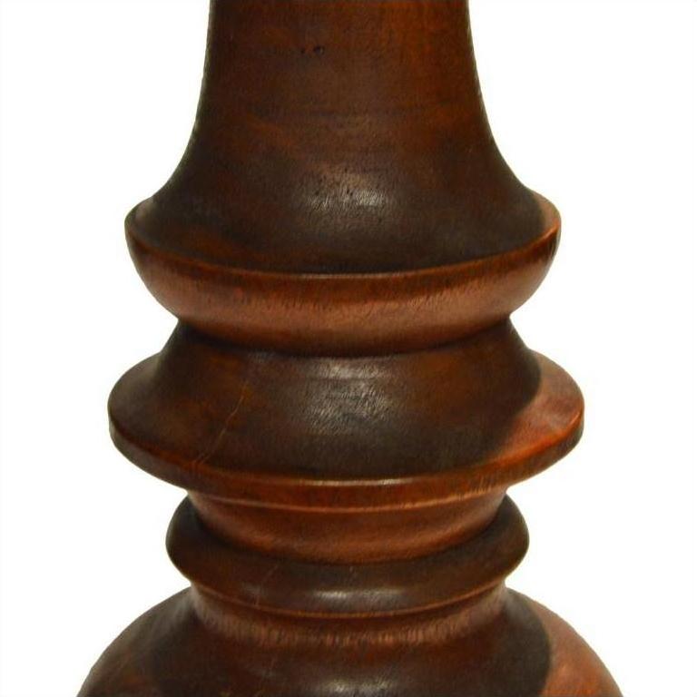Close-up of dark brown polished wood candle holder, hand carved with Dutch influence and smooth curved details.