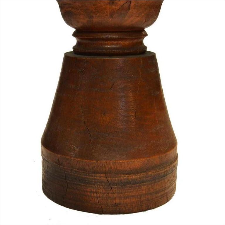Close-up of a weathered brown wooden hand-carved vintage candle holder with Dutch influence and textured surface.