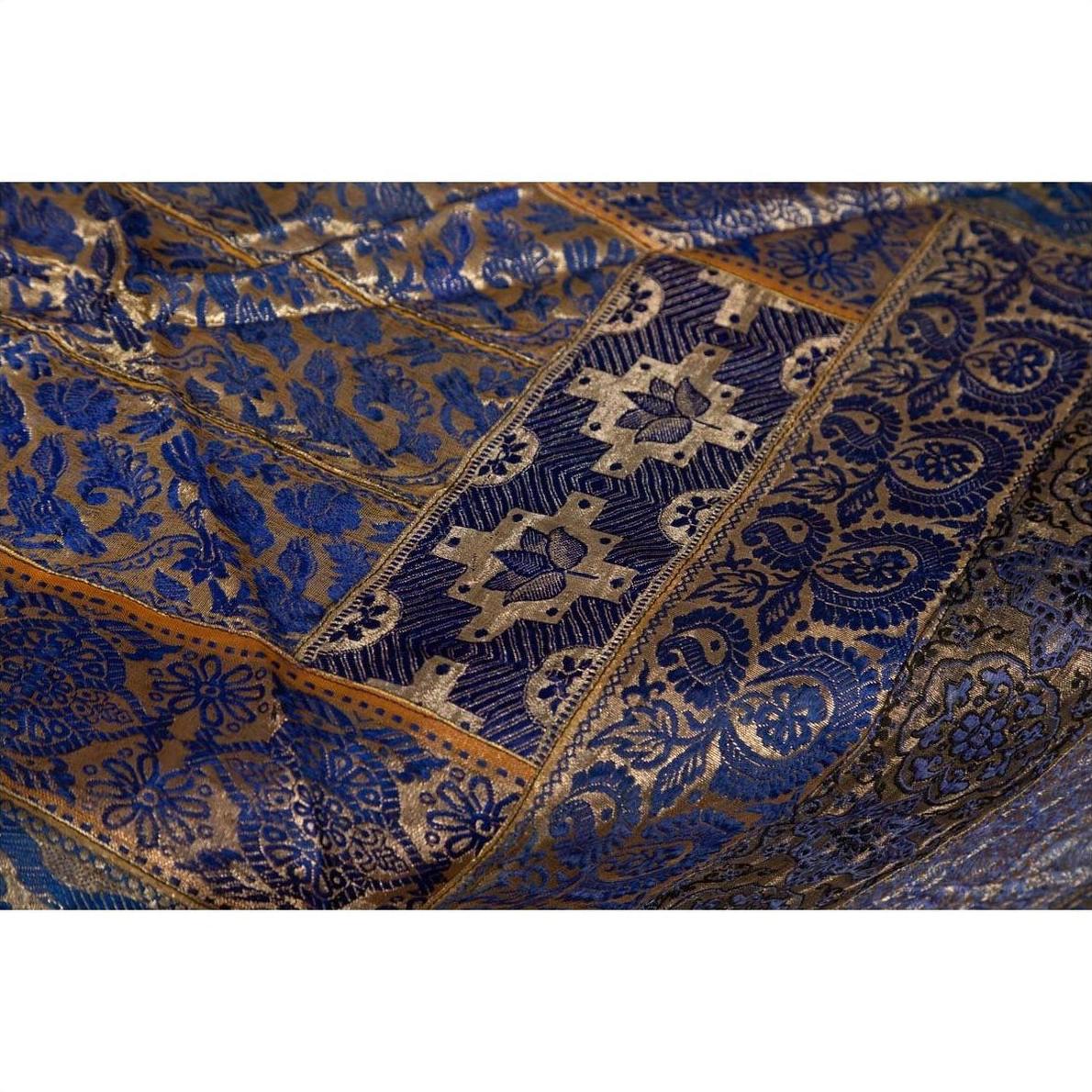 Close-up of purple silk fabric with floral and geometric embroidery in purple, silver, and gold.