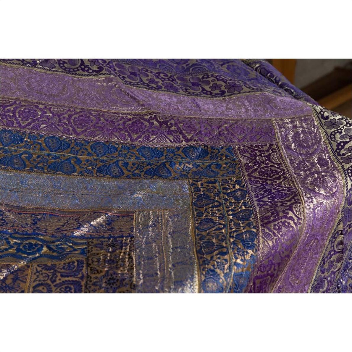 Close-up of purple silk fabric with silver and gold embroidery and floral designs, vintage Indian textile.