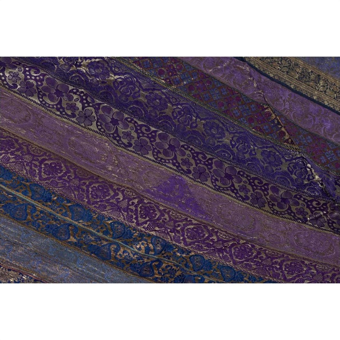 Purple silk fabric with diagonal embroidery in purple, silver, and gold tones, close-up.