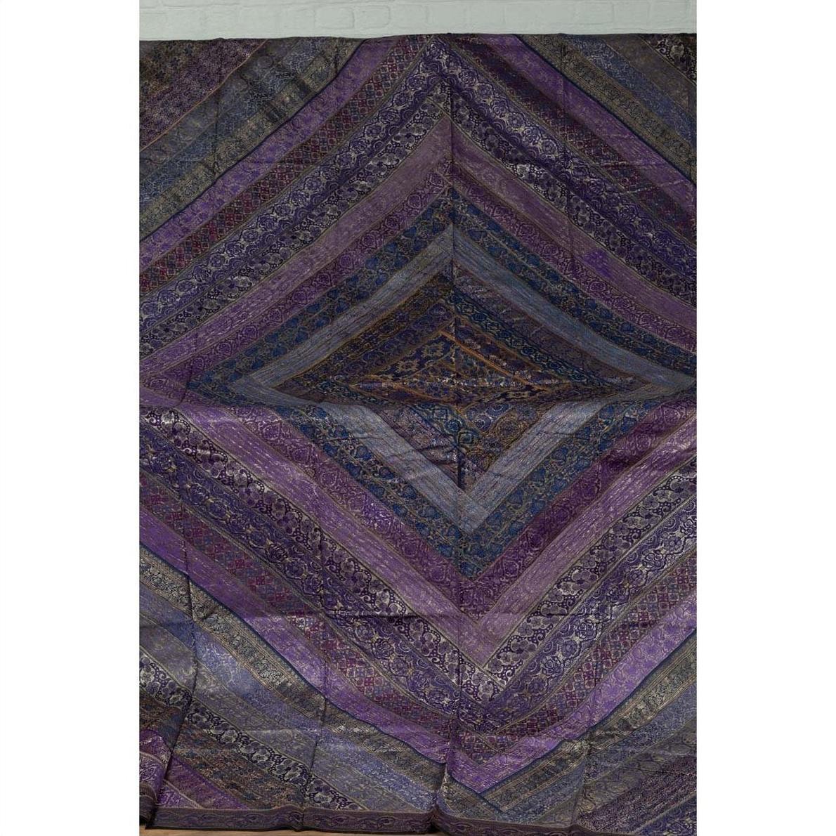 Purple silk fabric with purple, silver, and gold embroidery in intricate decorative patterns, close-up.