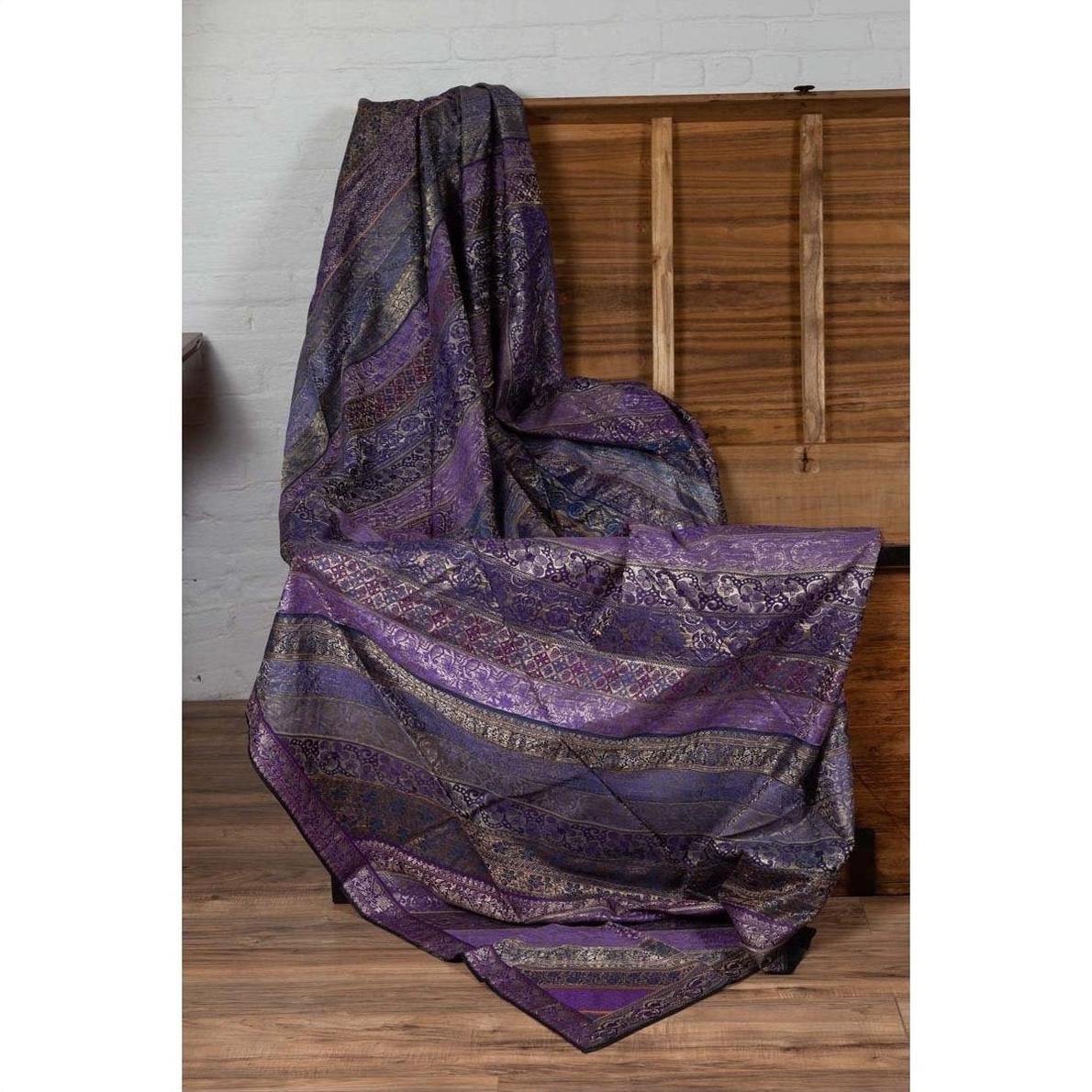 Purple silk fabric with gold and silver embroidery draped over a wooden chest.