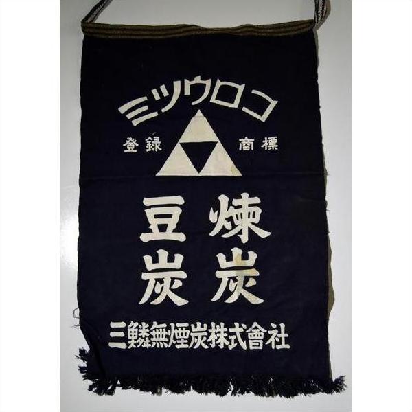Navy blue wax printed cotton apron with white Kanji and Katakana text, triangle logo, Taisho style, close-up.