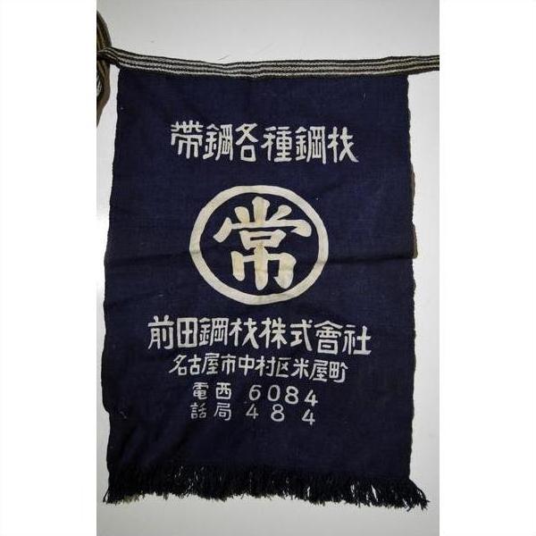 Dark blue wax printed cotton Japanese Taisho apron with white kanji, company name, contact info, and striped cord top.