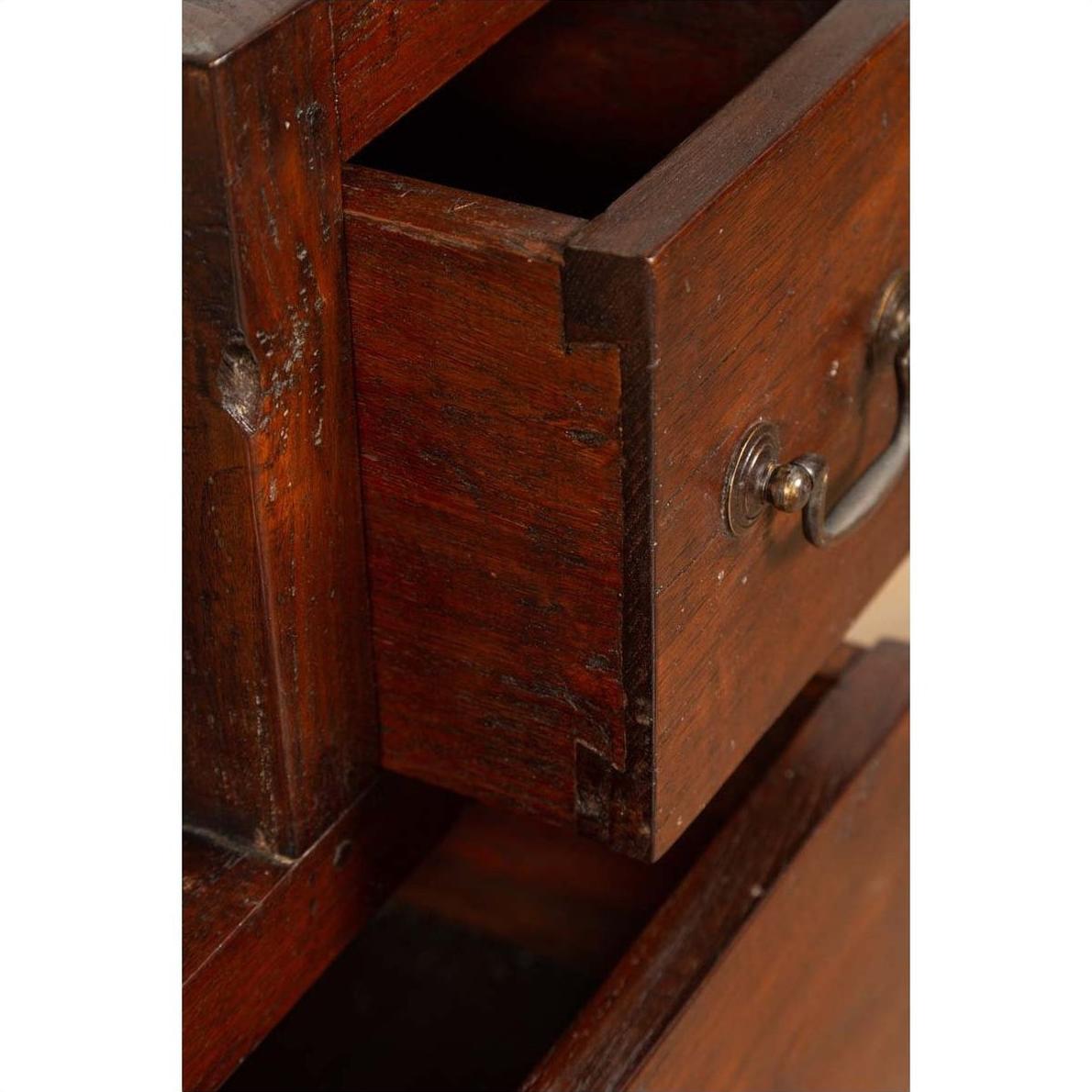 Close-up of brown wood drawer with metal handle, dovetail joints, in vintage Javanese Japanese-style cabinet.