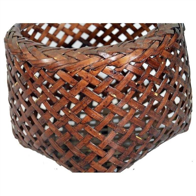 Close-up of a brown rattan woven basket with a detailed crisscross pattern and rich textured surface.