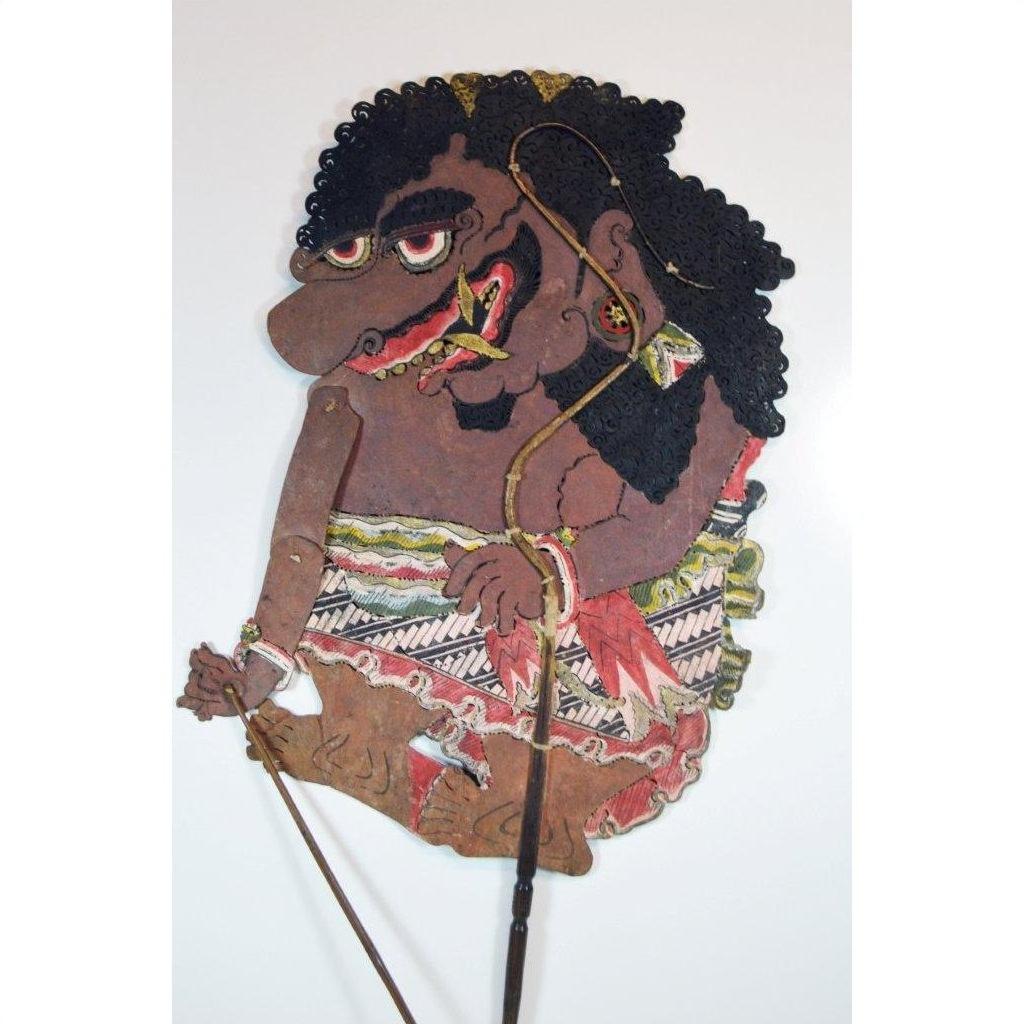 Colorful cowhide shadow puppet with curly hair and large nose, Balinese Wayang Kulit, close-up.