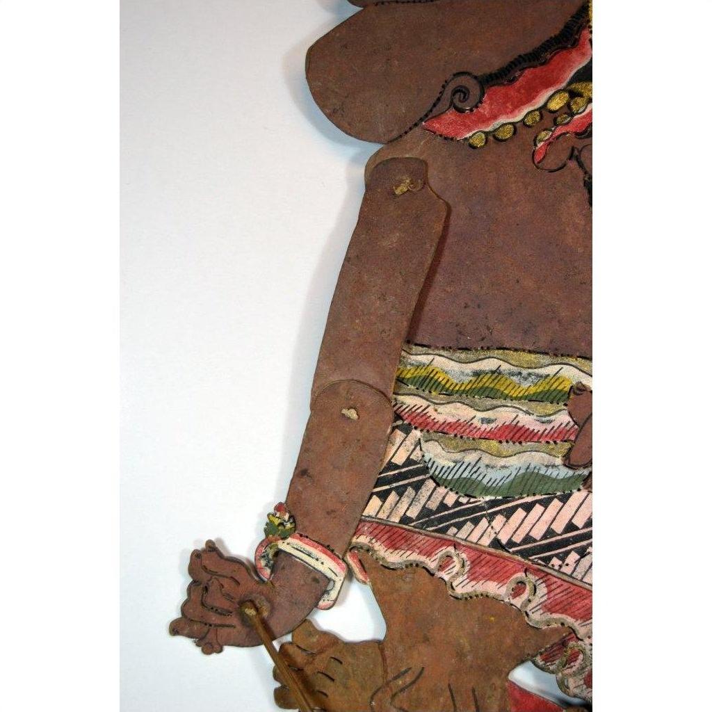 Close-up of colorful cowhide Wayang Kulit shadow puppet arm and costume, antique Balinese Indonesian style.