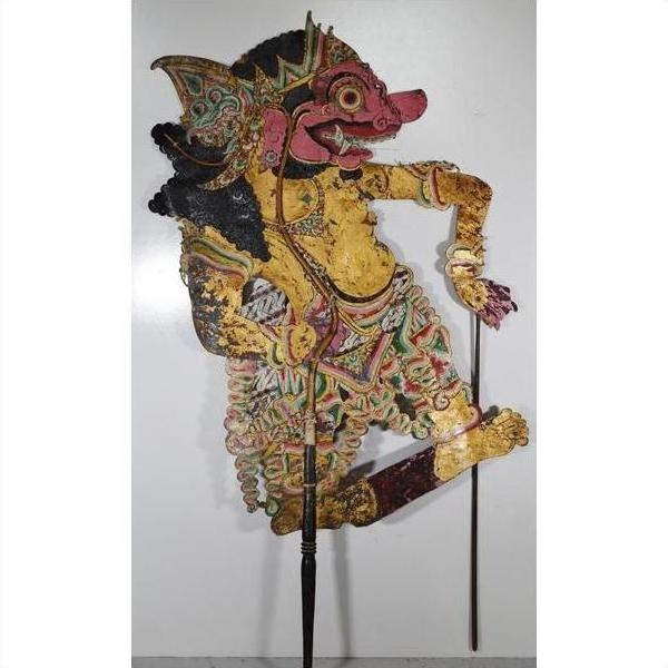 Close-up of Balinese Wayang Kulit shadow puppet, carved cowhide with intricate designs, two rods, balanced on one leg.