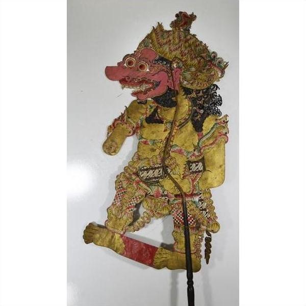 Colorful cowhide Wayang Kulit Balinese shadow puppet with ornate costume and exaggerated facial features, close-up.