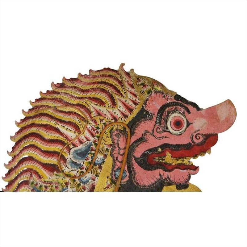 Balinese cowhide shadow puppet with pink snout, bulging eye, and striped mane in side profile.