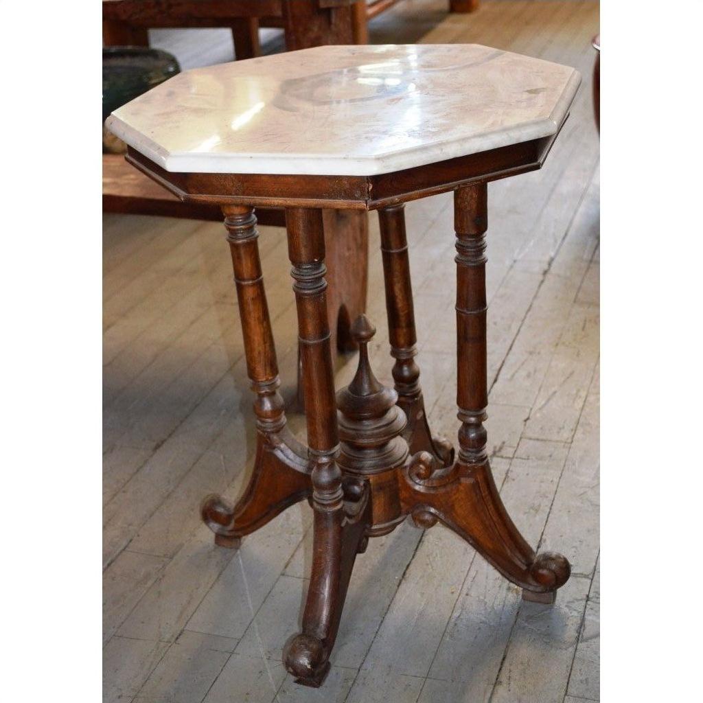 White marble side table with ornate legs and octagonal top, indoors on a wooden floor.