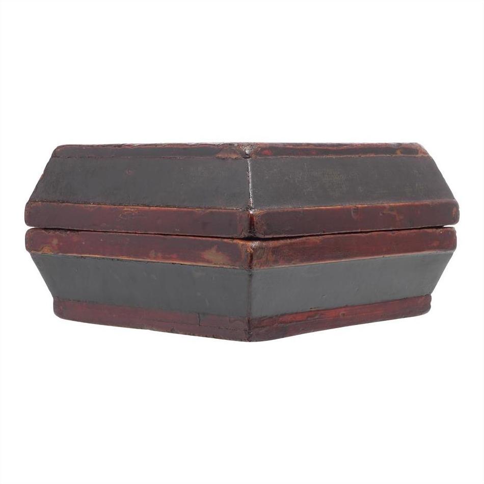 Hexagonal dark red and black wooden box with top, vintage document holder style and worn edges, close-up.