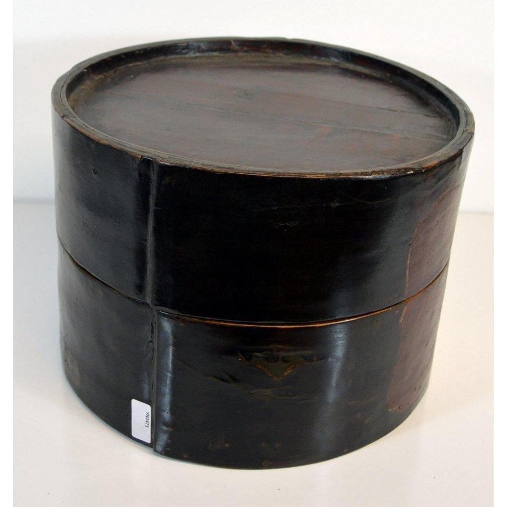 Light and dark wood round hat box with fitted lid, vintage style, close-up on plain white background.