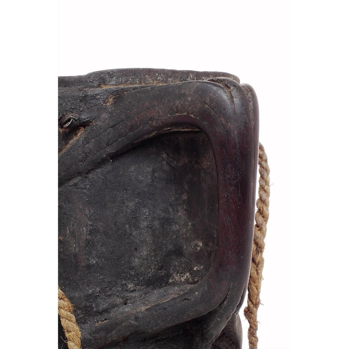 Close-up of dark wood Indian pitcher with textured surface and rope handles.