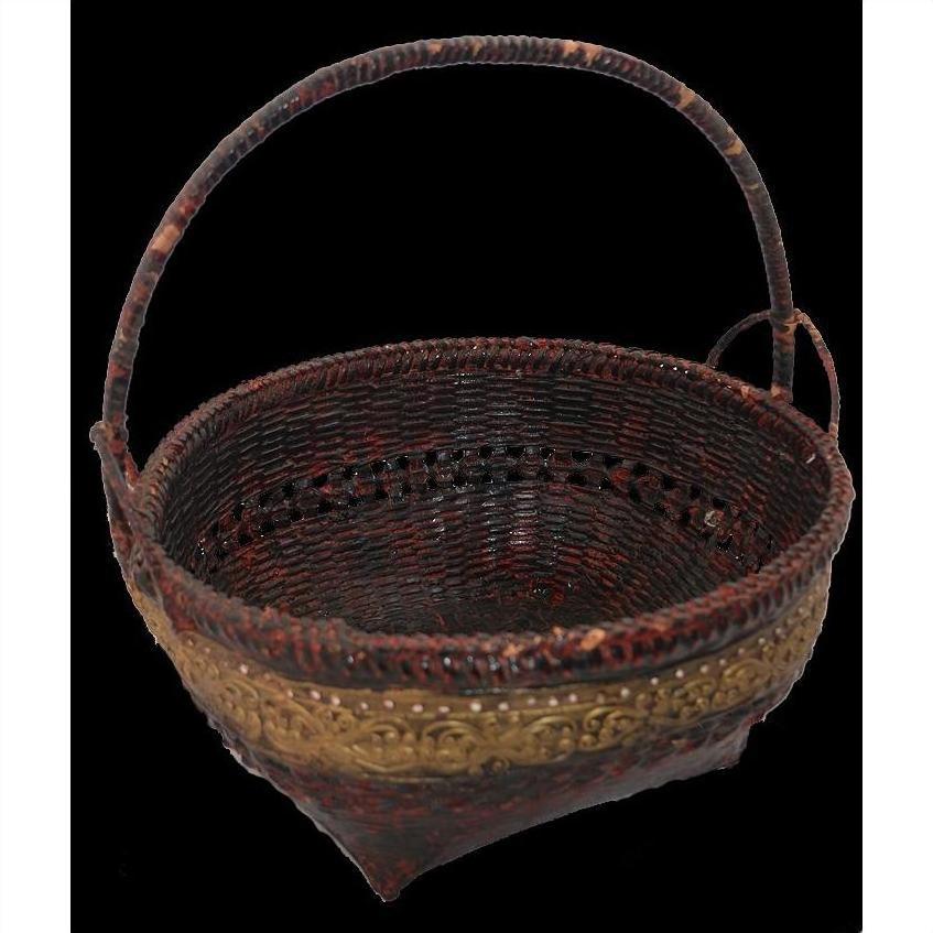 Natural bamboo basket with gold decorative band and sturdy handle, close-up on black background.