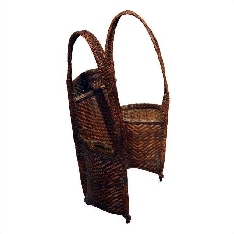 Natural rattan woven basket with two compartments and tall handles, close-up, for organized storage.