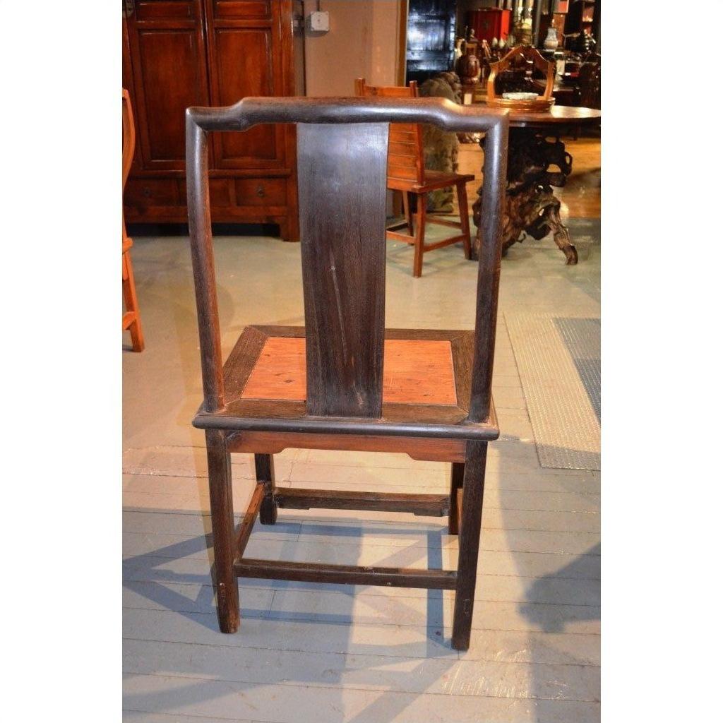 Dark brown wood Yoke Back Chair with burl wood seat, wide flat backrest, and square legs on a wooden floor.