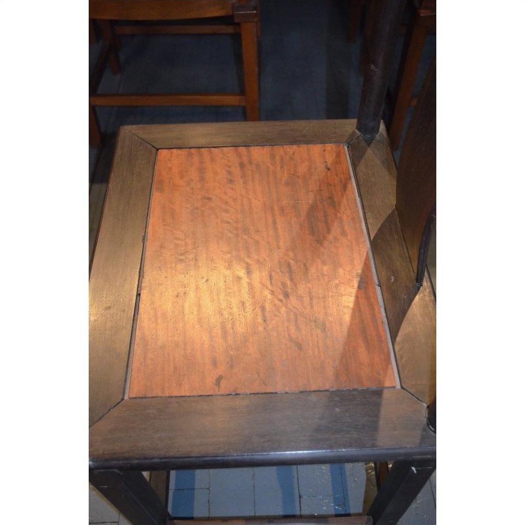 Close-up of a dark brown wood Yoke Back Chair with burl wood seat.